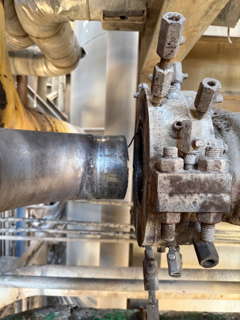 Industrial lathe machinery showing metal workpiece being machined next to an old stone tool holder with metal pins